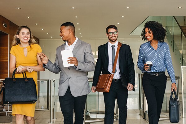 Four diverse colleagues walking down a hallway