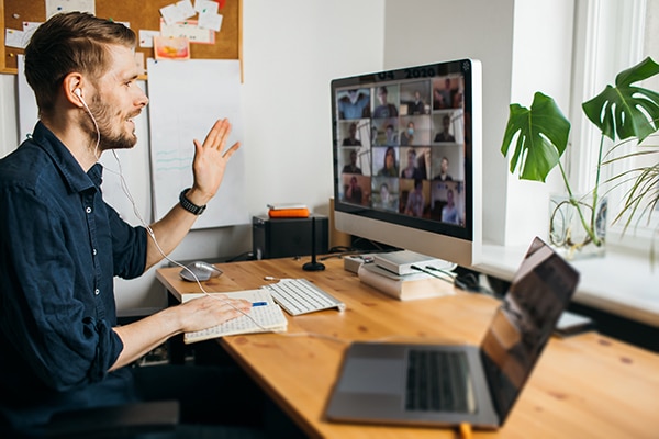man in an on-line meeting with many colleagues around the world
