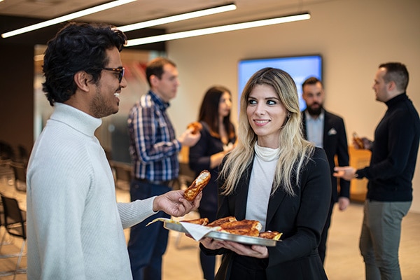 several colleagues converse and share a snack