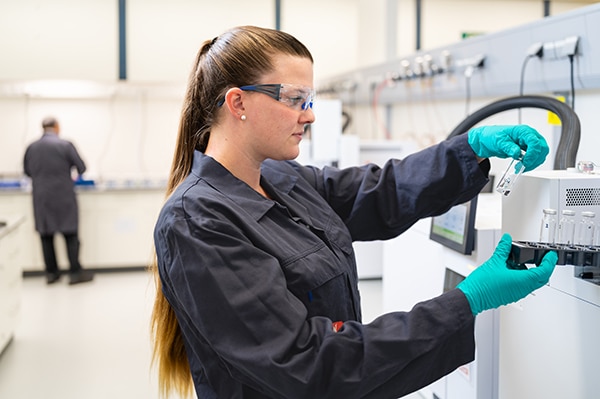 lab employee working with a sample at a sink