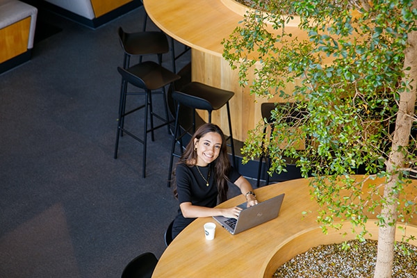 employee working on a computer smiles for the camera